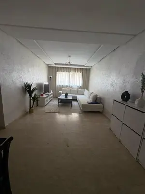 a large living room with a couch and a table at Appartement Vue sur piscine in Marrakech