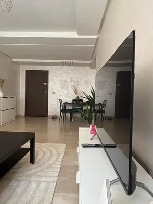 a living room with a table and a dining room at Appartement Vue sur piscine in Marrakech