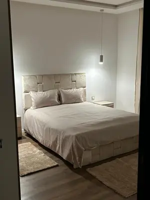 a bedroom with a large bed in a white room at Villa Tazinsky in Hbl Hmid