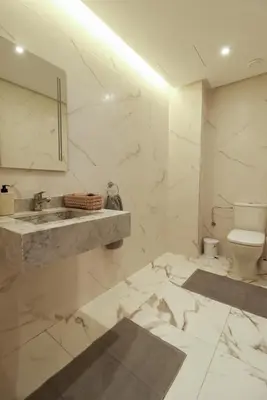 a white bathroom with a sink and a toilet at Piscine- Résidence haut de Gamme in Marrakech