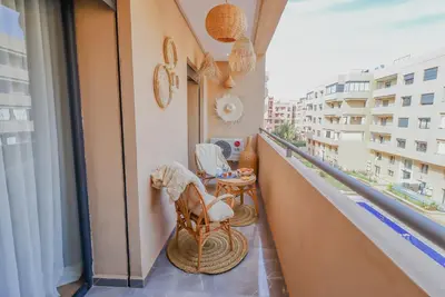 a balcony with chairs and a table on a balcony at Piscine- Résidence haut de Gamme in Marrakech