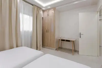 a bedroom with a bed and a cabinet and a table at Majorelle Retreat in Marrakech