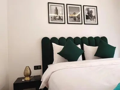 a bedroom with a large bed with green and white pillows at Stylish Apartment with Pool in Central Location Near Gueliz and Medina in Marrakech