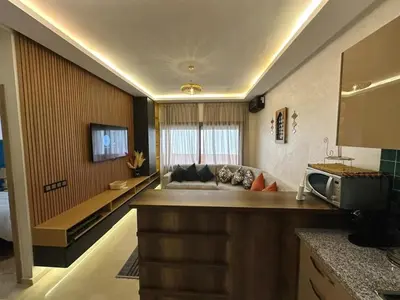 a living room with a couch and a television at Stylish Apartment with Pool in Central Location Near Gueliz and Medina in Marrakech