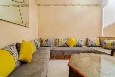 a living room with a couch with yellow pillows at Riad Zitoune in Marrakech