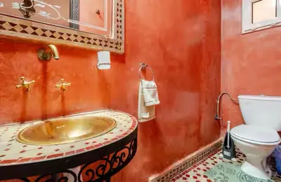 a bathroom with a gold sink and a toilet at Riad Zitoune in Marrakech