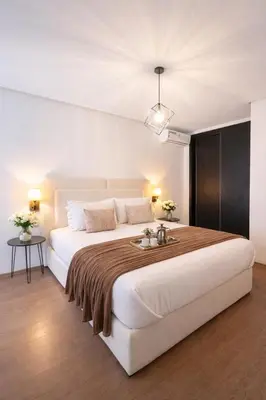 a bedroom with a large white bed with a brown blanket at Luxury apartment and free parking in Marrakech