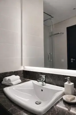a white sink in a bathroom with a mirror at Luxury apartment and free parking in Marrakech