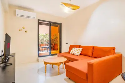 a living room with an orange couch and a table at Exclusive Family Appartement in Marrakech