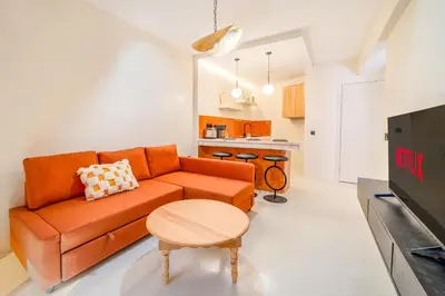 a living room with an orange couch and a table at Exclusive Family Appartement in Marrakech