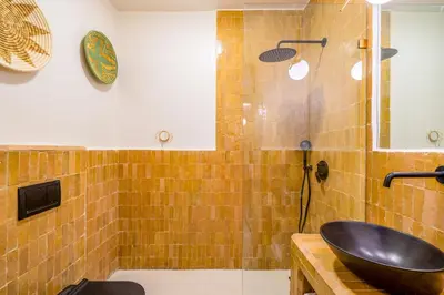 a bathroom with a black sink and a tub at Exclusive Family Appartement in Marrakech