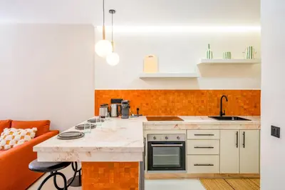 a kitchen with an orange and white counter top at Exclusive Family Appartement in Marrakech