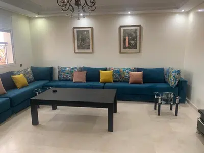 a living room with a blue couch and a coffee table at Asmae in Marrakech