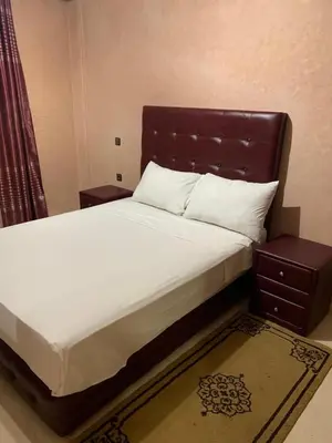 a bedroom with a large bed with a wooden headboard at Asmae in Marrakech