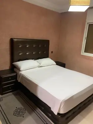 a bedroom with a large bed with white sheets at Asmae in Marrakech