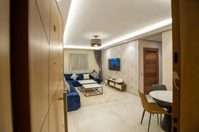 a living room with a blue couch and a table at Luxury 2-Bedroom Apartment with Balcony - Heart of Gueliz in Marrakech
