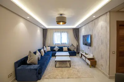 a living room with a blue couch and a table at Luxury 2-Bedroom Apartment with Balcony - Heart of Gueliz in Marrakech