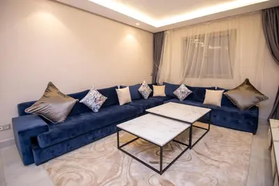 a living room with a blue couch with pillows at Luxury 2-Bedroom Apartment with Balcony - Heart of Gueliz in Marrakech