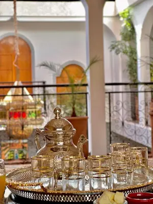 a tray of glasses and a tea kettle on a table at Riad Dar Mima Hnina - Your Traditional and Private haven of peace, 2 pools, 10' from airport in Marrakech