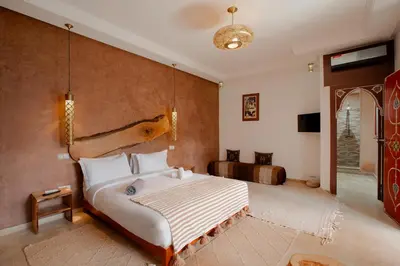 a bedroom with a large white bed in a room at Riad Dar Mima Hnina - Your Traditional and Private haven of peace, 2 pools, 10' from airport in Marrakech