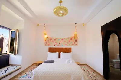 a bedroom with a bed with a white bedspread at Riad Dar Mima Hnina - Your Traditional and Private haven of peace, 2 pools, 10' from airport in Marrakech