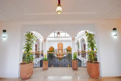 a lobby with potted plants and a fountain at Riad Dar Mima Hnina - Your Traditional and Private haven of peace, 2 pools, 10' from airport in Marrakech