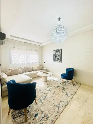 a living room with a couch and chairs and a chandelier at Charmant Appartement 2 Room Wifi Marrakech in Marrakech