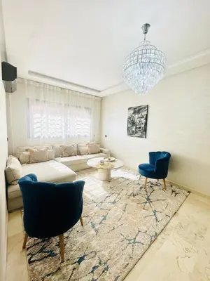 a living room with a couch and chairs and a chandelier at Charmant Appartement 2 Room Wifi Marrakech in Marrakech
