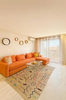 a living room with an orange couch and a rug at Chic 1 bedroom WiFi apartment Marrakech in Marrakech