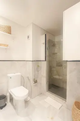 a white bathroom with a toilet and a shower at Chic 1 bedroom WiFi apartment Marrakech in Marrakech