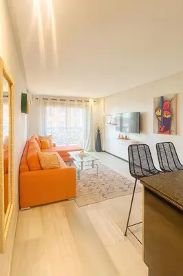 a living room with an orange couch and a table at Chic 1 bedroom WiFi apartment Marrakech in Marrakech