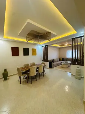 a living room with a table and chairs and a couch at Elegant 2 Bedrooms with Pool & Wi-Fi Marrakech in Marrakech
