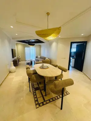 a dining table and chairs in a living room at Sublime 2 bedrooms with pool and Wi-Fi Marrakech in Marrakech