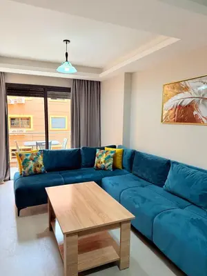 a living room with a blue couch and a table at A21 Moderne Confort Au Cœur De Marrakech in Marrakech
