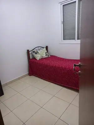 a bed in a room with a red blanket and a window at Appartement au centre de marrakech in Marrakech