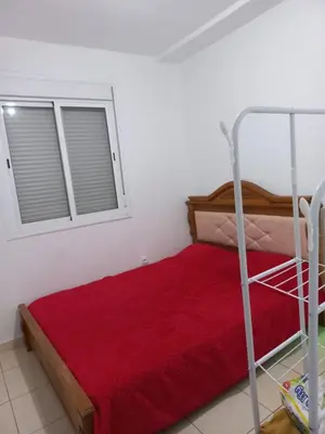 a bedroom with a bed with a red blanket and a window at Appartement au centre de marrakech in Marrakech