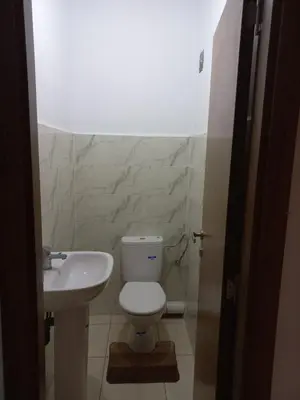 a bathroom with a white toilet and a sink at Appartement au centre de marrakech in Marrakech