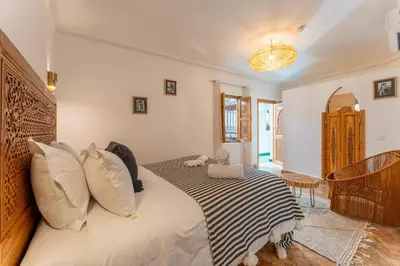 a bedroom with a bed with a black and white blanket at Riad OM SAADENE in Marrakech