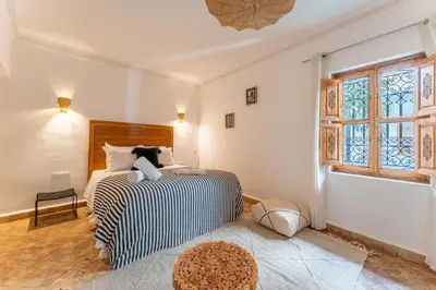 a bedroom with a bed and a large window at Riad OM SAADENE in Marrakech
