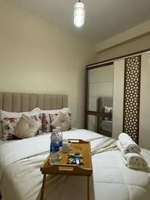 a bedroom with a bed and a table with water bottles on it at Modern Apartment Near Airport in Marrakech