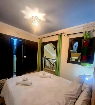 a bedroom with a bed with two towels on it at Riad Ibrahim in Marrakech