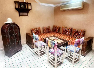 a living room with a couch and a table and chairs at Riad Ibrahim in Marrakech
