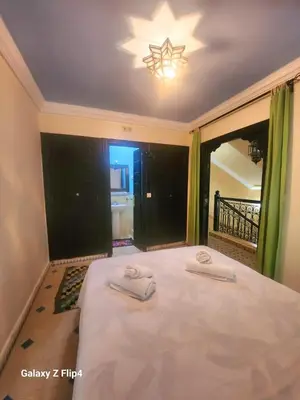 a bedroom with a bed with two towels on it at Riad Ibrahim in Marrakech