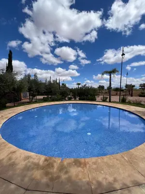 a large blue pool with a cloudy sky in the background at Resort Apartment Golf View in Marrakech
