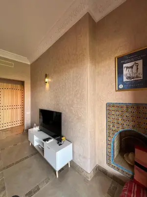 a living room with a tv on a wall at Resort Apartment Golf View in Marrakech