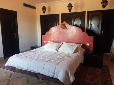 a bedroom with a large bed with a red headboard at Beautiful villa with a private pool in La Palmeraie neighborhood in Marrakech
