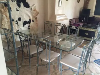 a glass table and chairs in a living room at Beautiful villa with a private pool in La Palmeraie neighborhood in Marrakech