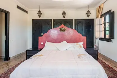 a bedroom with a large bed with a red headboard at Beautiful villa with a private pool in La Palmeraie neighborhood in Marrakech