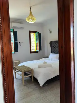 a bedroom with a bed and a table and a lamp at Riad suite for families and groups in Marrakech