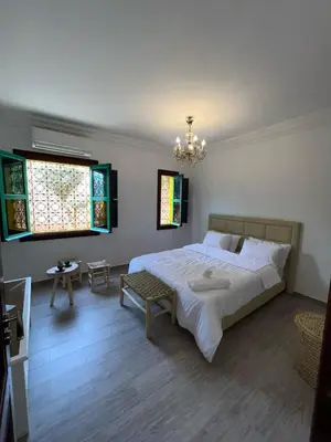 a bedroom with a large bed and a chandelier at Riad suite for families and groups in Marrakech